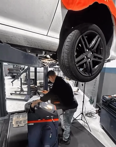 Técnico operando máquina de troca de fluido de câmbio automático na oficina